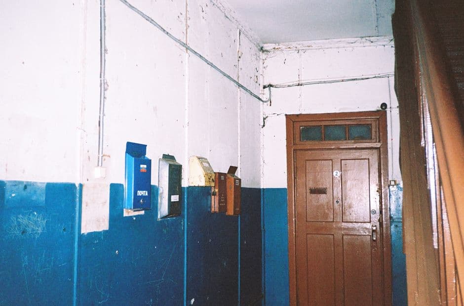 A wall-mounted bank of numbered metal mailboxes in a residential lobby, one door slightly ajar.