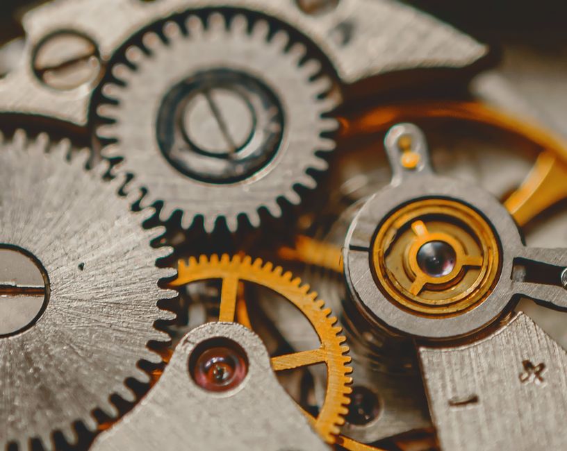 Interlocking steel and brass gear wheels seen from above at close range.